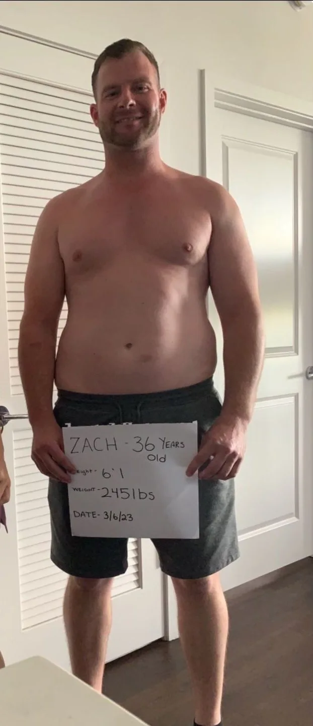 Zach holding a sign recording his March 2023 starting point at age 36 and 245 pounds