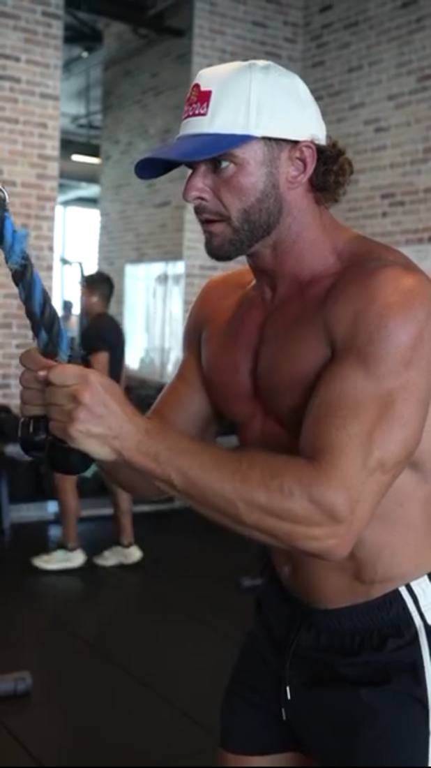 Zach White, founder of BioKingdom Health, training with a cable rope in a gym